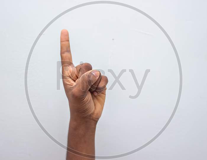 Boy Hand Showing Number One Gesture Symbol Isolated On White Background. Gesturing Number 1. Number One In Sign Language. Counting Down One Concept. One Fingers Up. Man Hand Sign Victory Gesture.