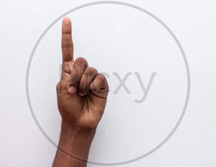 Boy Hand Showing Number One Gesture Symbol Isolated On White Background. Gesturing Number 1. Number One In Sign Language. Counting Down One Concept. One Fingers Up. Man Hand Sign Victory Gesture.