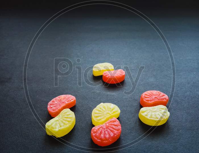 Colorful orange candies in black background