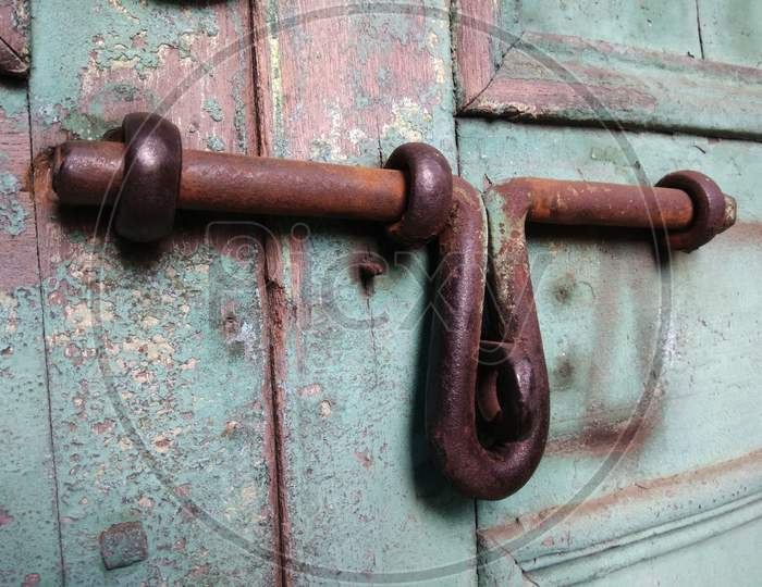 Old rusty door handle on a wooden door