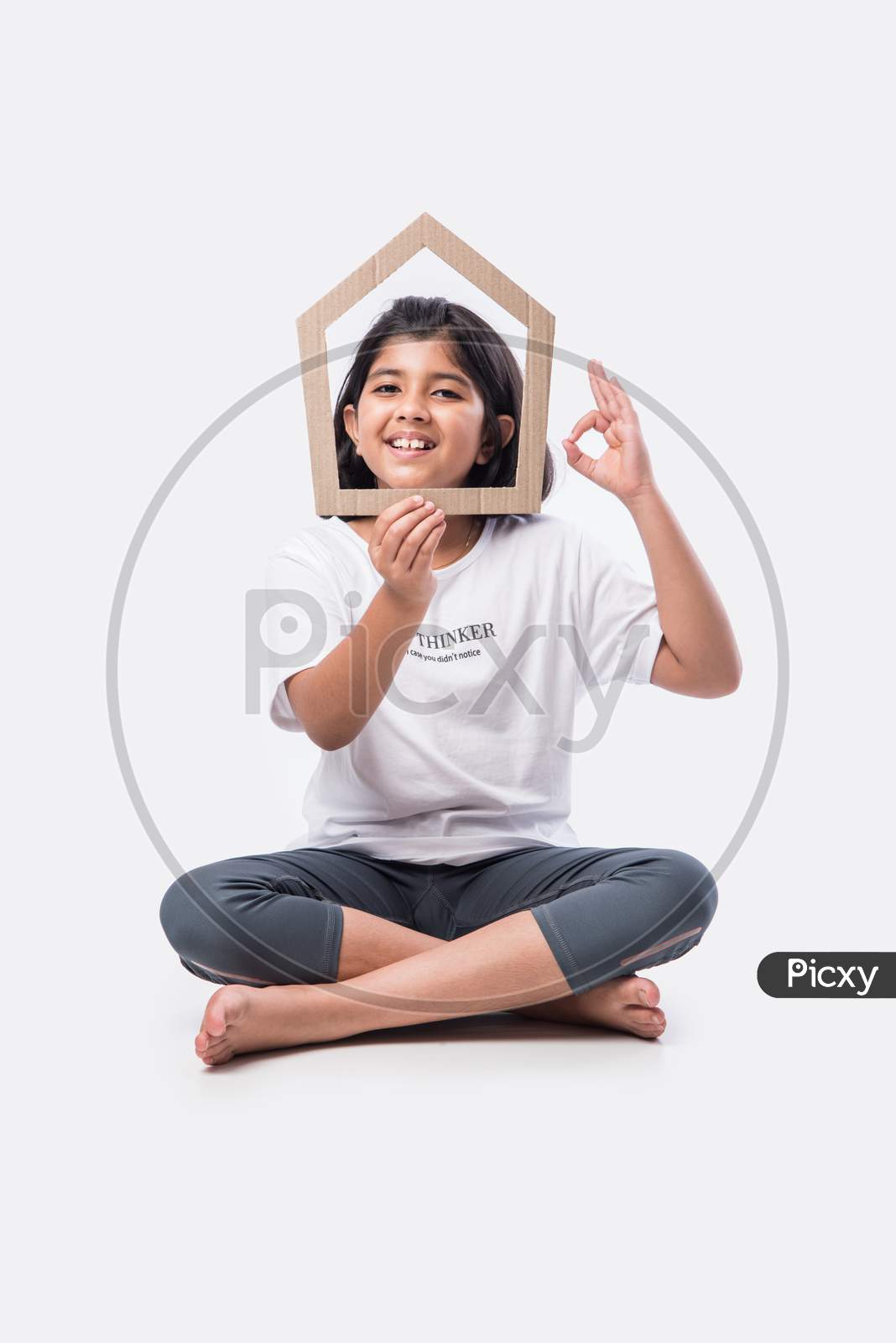 Indian Asian Little Girl Holding Paper House Model Against White Background - Home & Family Concept
