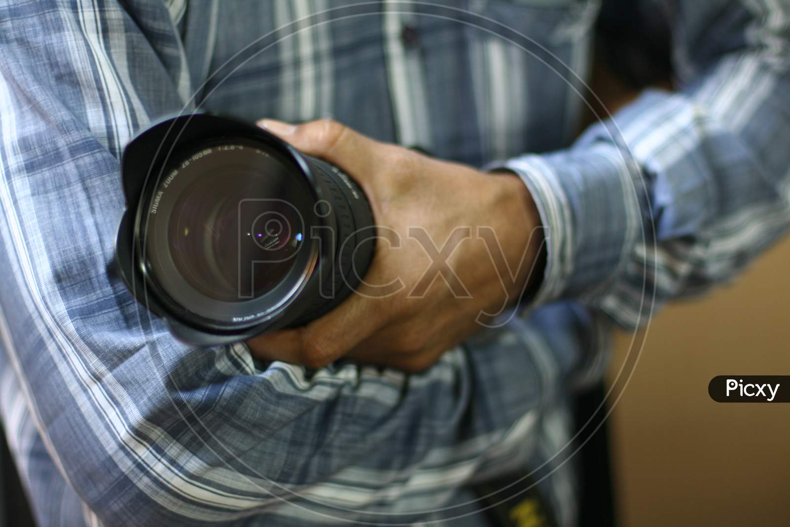A man holding a camera lens in his hand