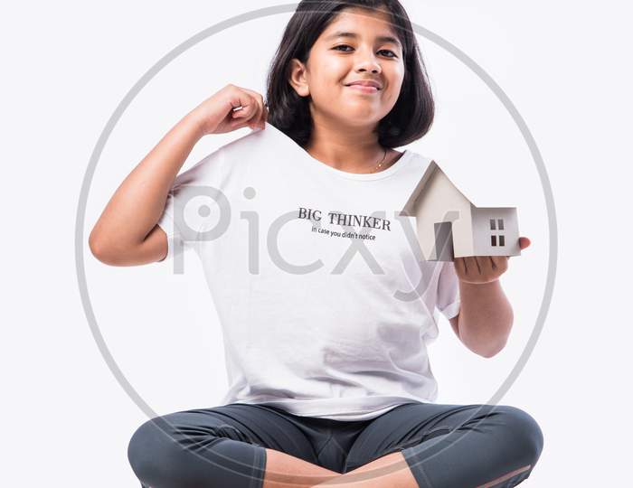 Indian Asian Little Girl Holding Paper House Model Against White Background - Home & Family Concept