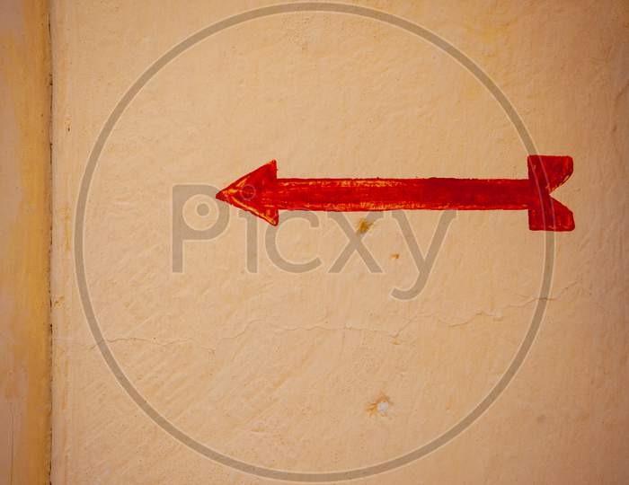 Painted Red Arrow Closeup On Yellow Wall