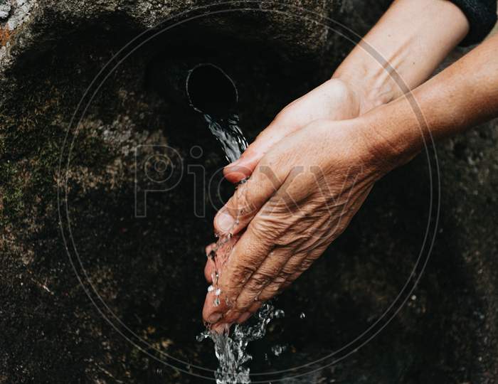 Old Woman Washing Her Hands Close Up Of The Hands In A Source Font With Natural Water