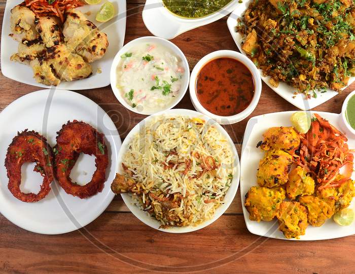 Assorted Indian Foods Reshmi Kebab, Afghani Kebab,Chicken Biryani And Fish Fry On Wooden Background. Dishes And Appetizers Of Indian Cuisine