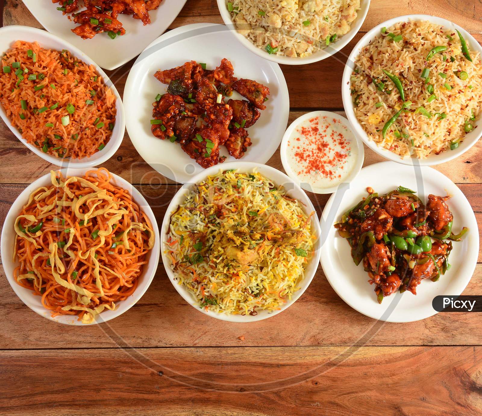 Assorted Indian Foods Dragon Chicken,Chicken Biryani,Chicken Fried Rice,Veg Noodles And Garlic Chicken On Wooden Background. Dishes And Appetizers Of Indian Cuisine