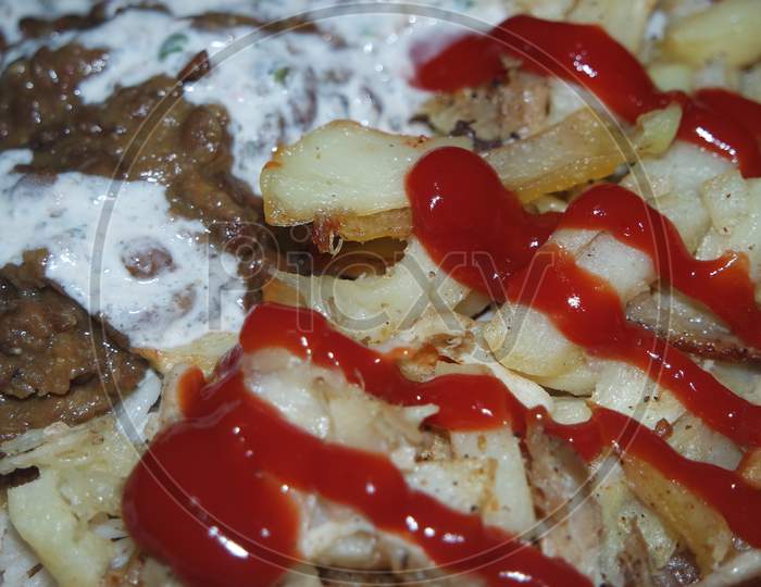 Delicious Traditional Dish Of Rice, Potato Fries And Cereals With Red Ketchup.