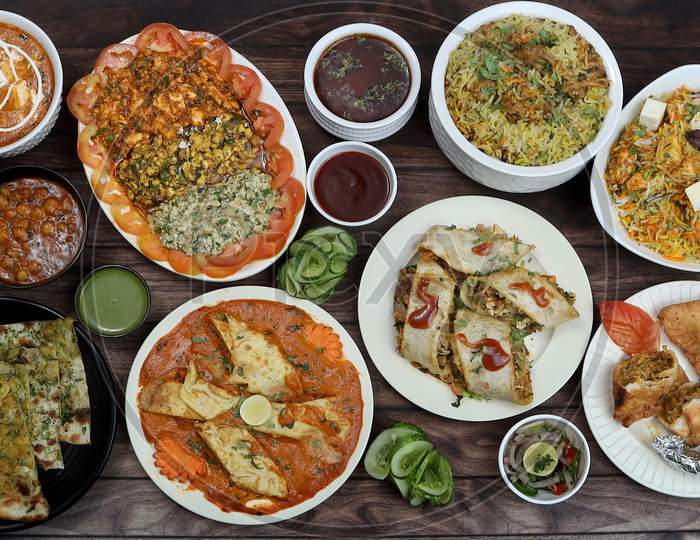 Assorted Indian Foods Chicken Biryani,Paneer Biryani, Kulcha, Tandoori Chicken And Spring Roll On Wooden Background. Dishes And Appetizers Of Indian Cuisine