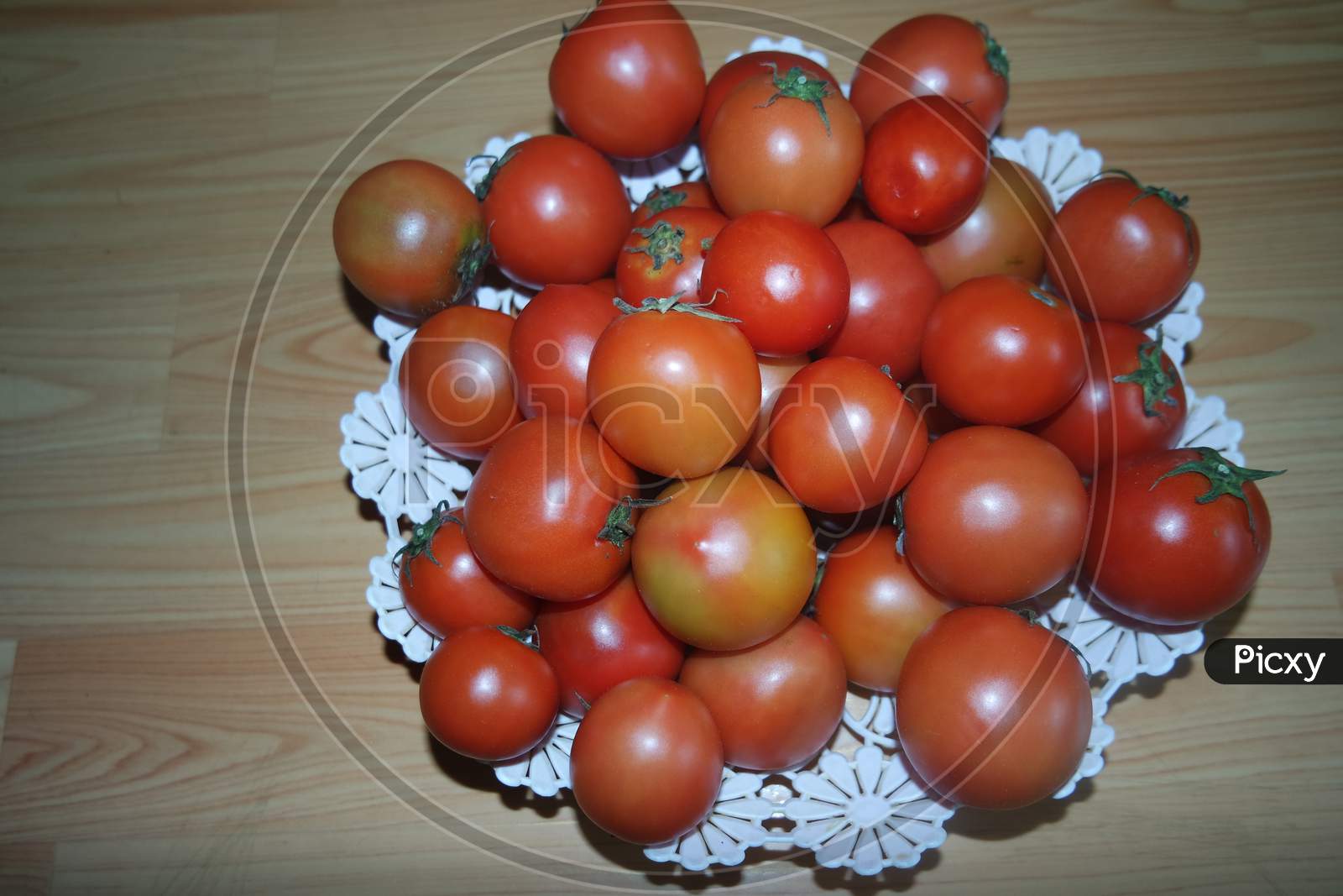 Close-Up View Of Red Tomatoes In White Basket On A Wooden Floor In Market