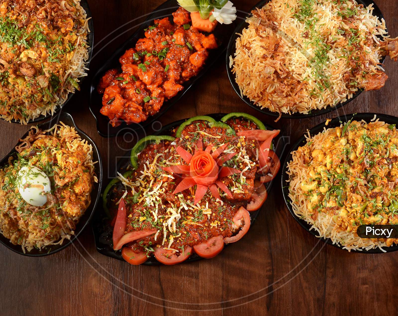 Assorted Indian Foods Mughal Chicken Biryani,Chicken Manchurian,Kaju Biryani,Chicken Dum Biryani And Egg Biryani On Wooden Background. Dishes And Appetizers Of Indian Cuisine