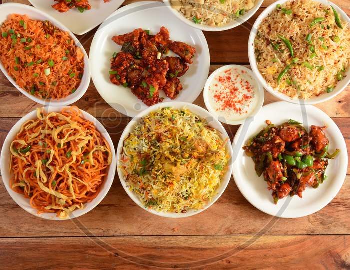 Assorted Indian Foods Dragon Chicken,Chicken Biryani,Chicken Fried Rice,Veg Noodles And Garlic Chicken On Wooden Background. Dishes And Appetizers Of Indian Cuisine