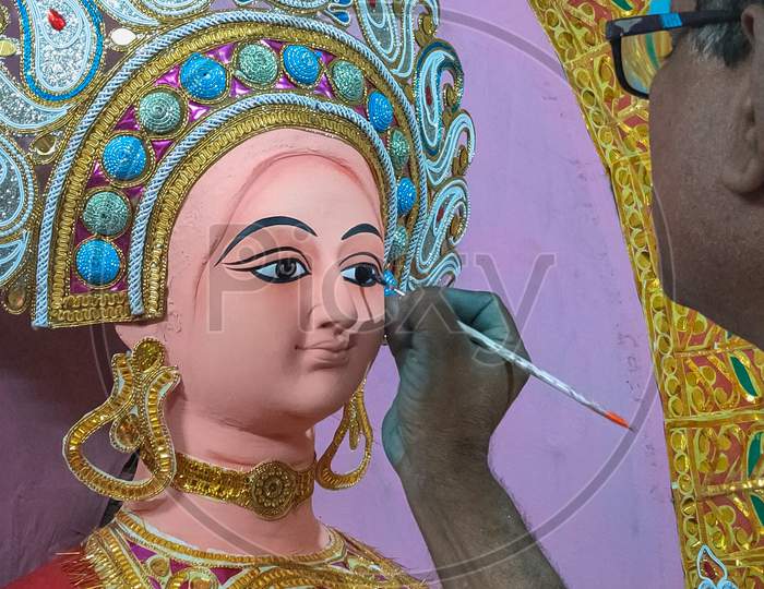 The man is giving life to the Clay Idol Maa Laxmi.
