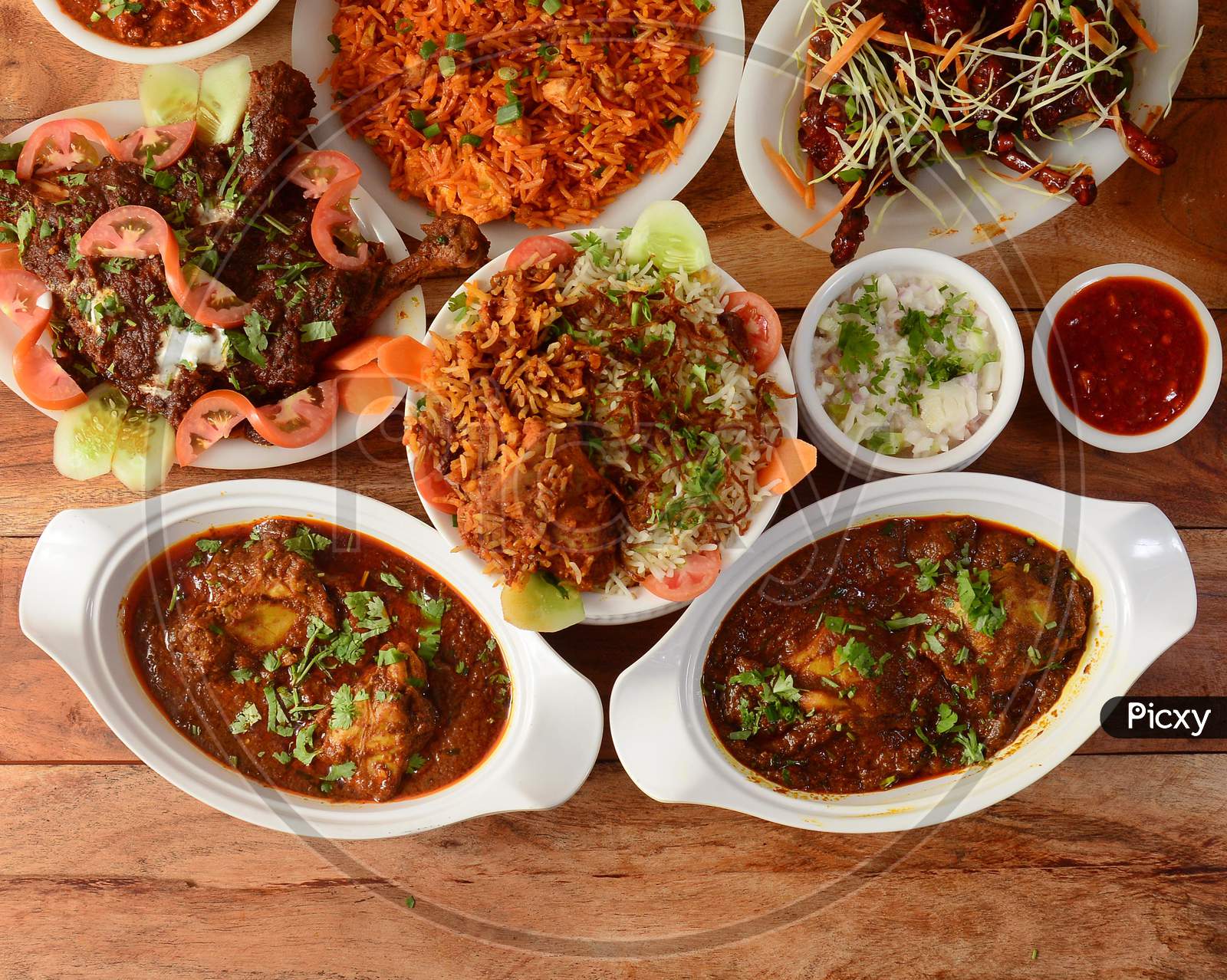 Assorted Indian Foods Chicken Biryani,Chicken Masala,Chicken Korma And Chicken Lollipop On Wooden Background. Dishes And Appetizers Of Indian Cuisine