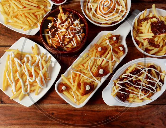 Variety Of Assorted French Fries On Plates With Mayonnaise And Tomato Sauce