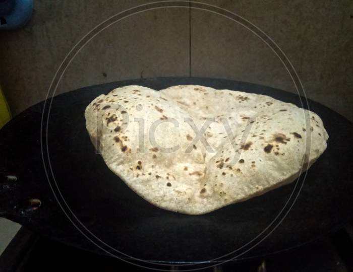 Cooking Roti Also Known As South Asian Bread, Chapati Or Pulka.