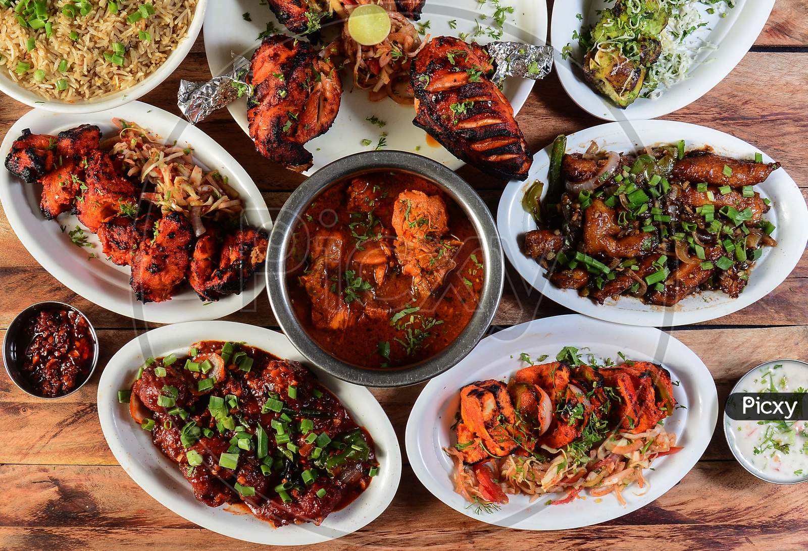 Assorted Indian Foods Chicken Pahadi Kebab,Chicken Angara Kebab,Tandoori Chicken,Pepper Chicken, Paneer Tikka And Chicken Masala On Wooden Background. Dishes And Appetizers Of Indian Cuisine