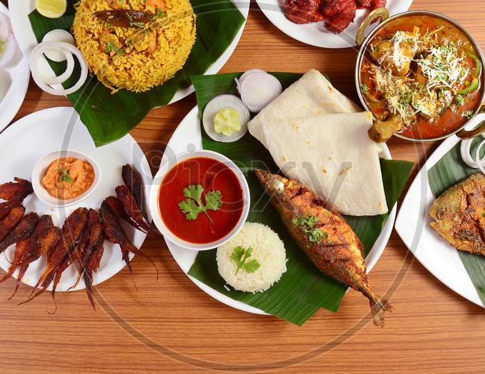 Assorted Indian Sea Foods Fish Curry Meal, Nethili Fry,Prawn Biryani, Pomfret Tawa Fry And Butter Chicken Masala On Wooden Background. Dishes And Appetizers Of Indian Cuisine