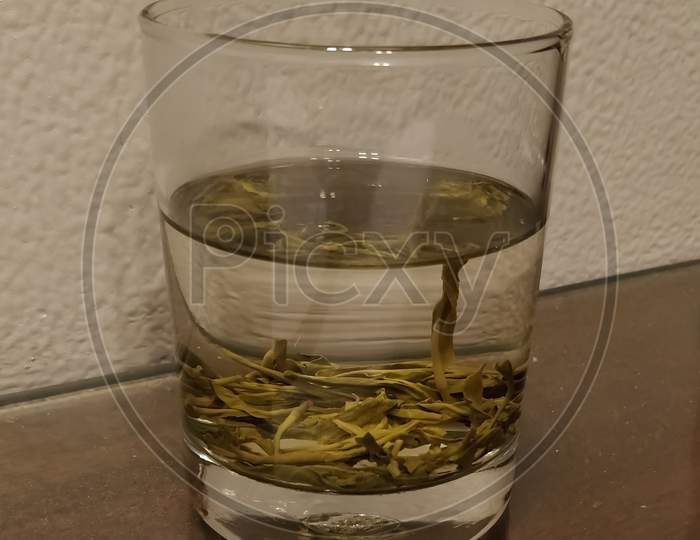 Green tea in a transparent glass on a table