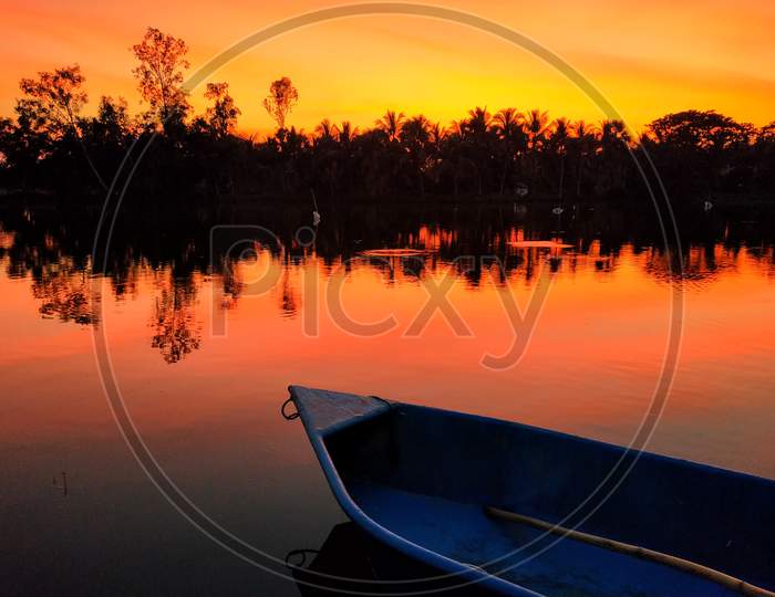 sunset, reflection of colorful sky on water, small boat, twilight