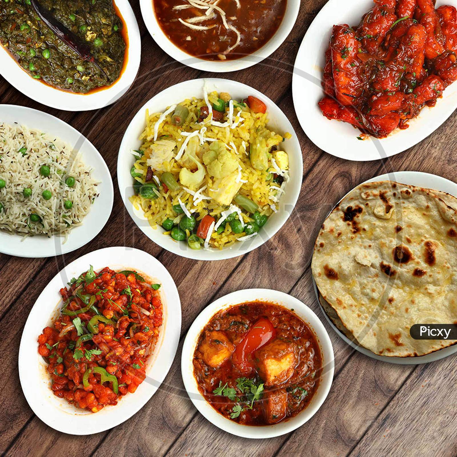 Assorted Indian Foods Veg Biryani,Crispy Corn,Crispy Paneer And Butter Naan On Wooden Background. Dishes And Appetizers Of Indian Cuisine