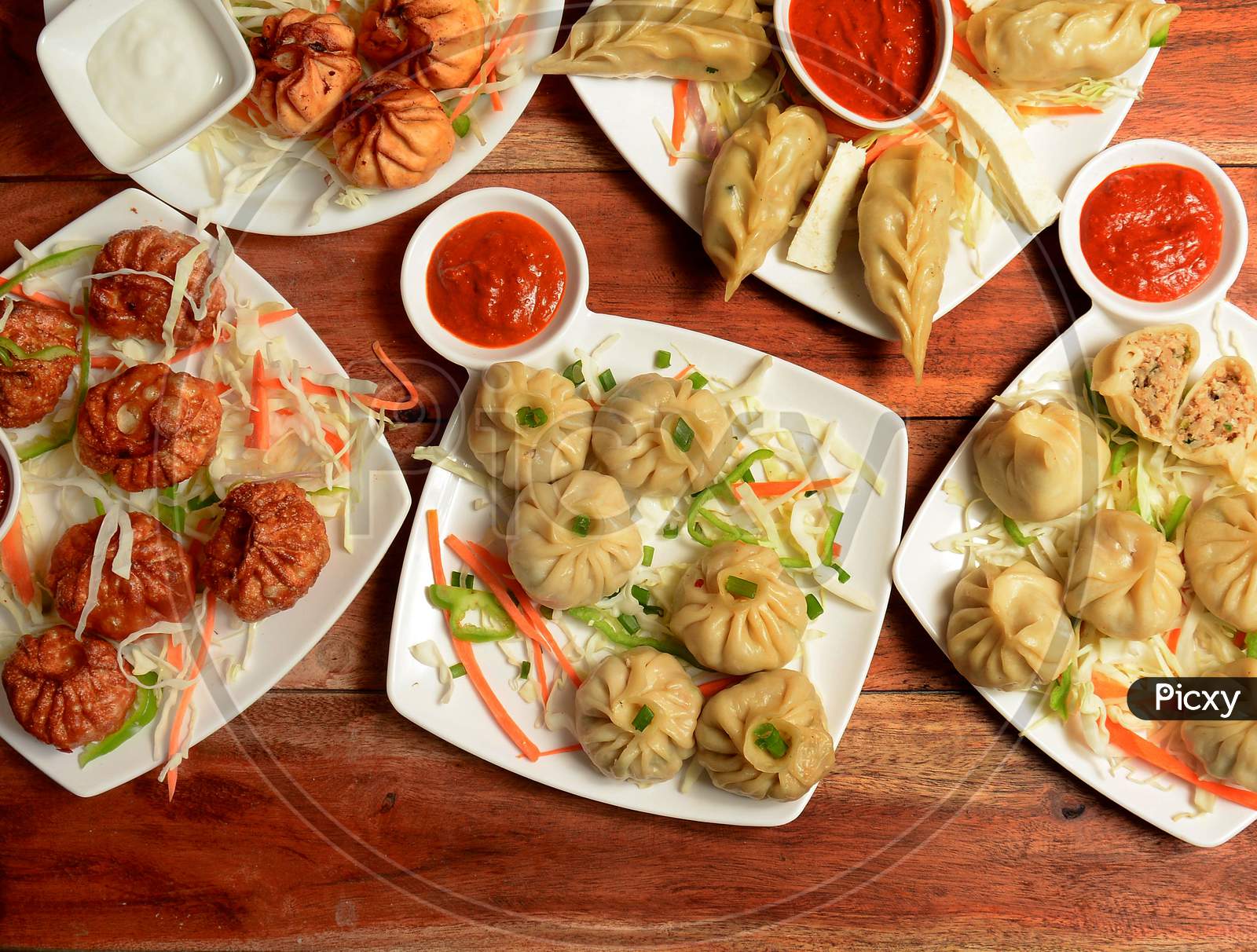 Variety Of Nepalese Traditional Dumpling Momos Served With Tomato Ketchup And Fresh Salad.