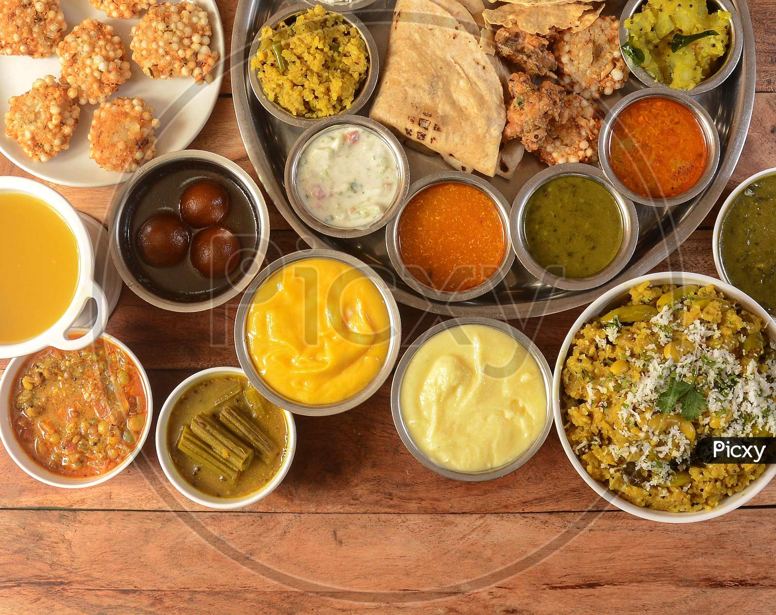 Assorted Indian Food Veg Thali On Wooden Background. Dishes And Appetizers Of Indian Cuisine