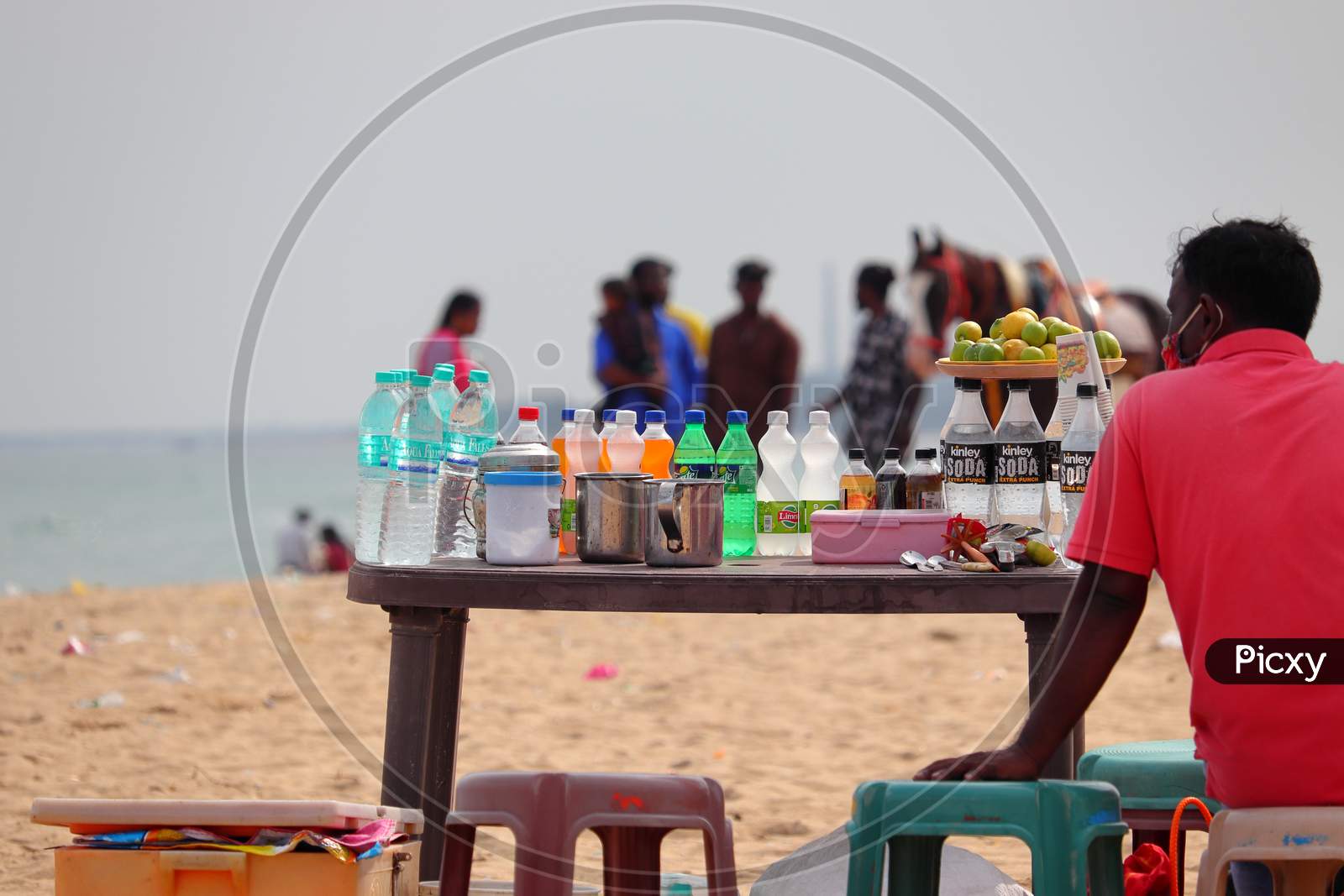 On The Beach, A Shopkeeper Shops And Sells A Product That Relieves The Heat Of The Tourists.