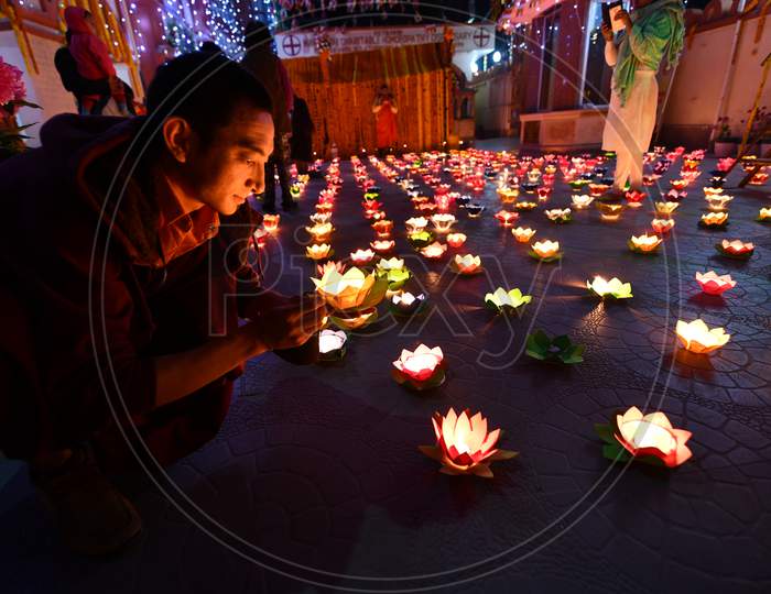 Buddhist Monks And Devotees lighting lamp