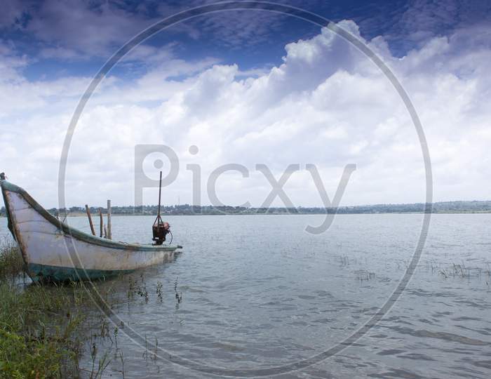 A Picturesque view of an Abandoned Boat and the deep blue skies on the banks of Kabini backwaters near Mysuru in Karnataka/India.