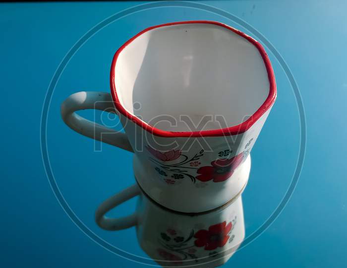 Tea cup with reflection, cup on blue background