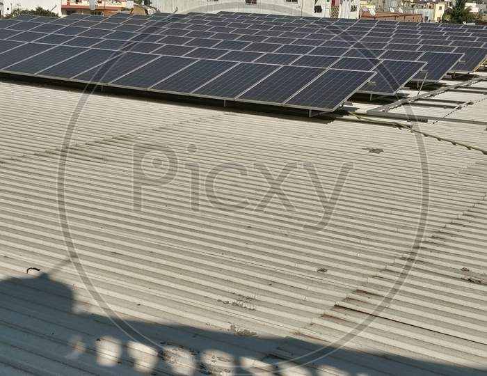 Solar panels on building roof with urban skyline