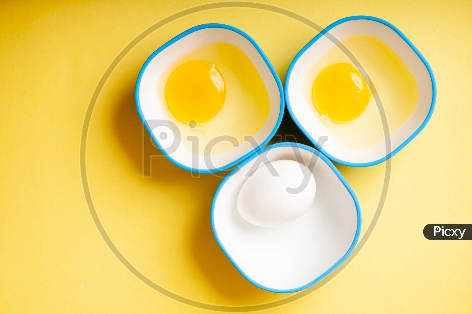 Raw Egg & Yellow Yolk In Three Bowls