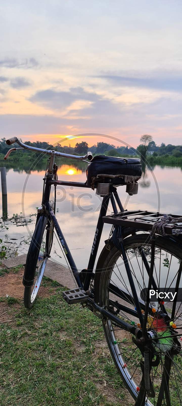 Bicycle with pond and sunset