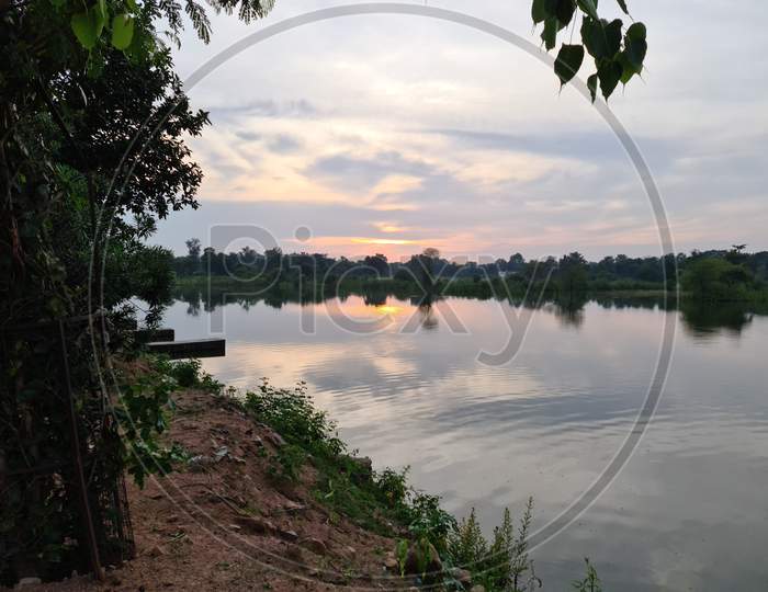 Photo of pond with sunset reflection