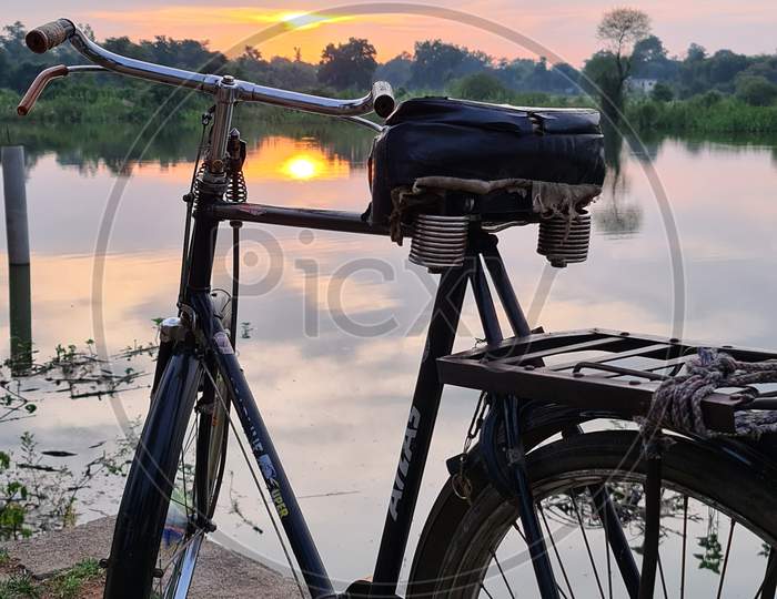 Bicycle with pond and sunset