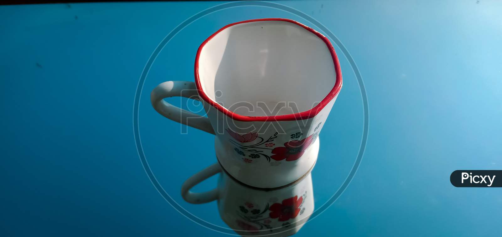 Tea cup with reflection, cup on blue background