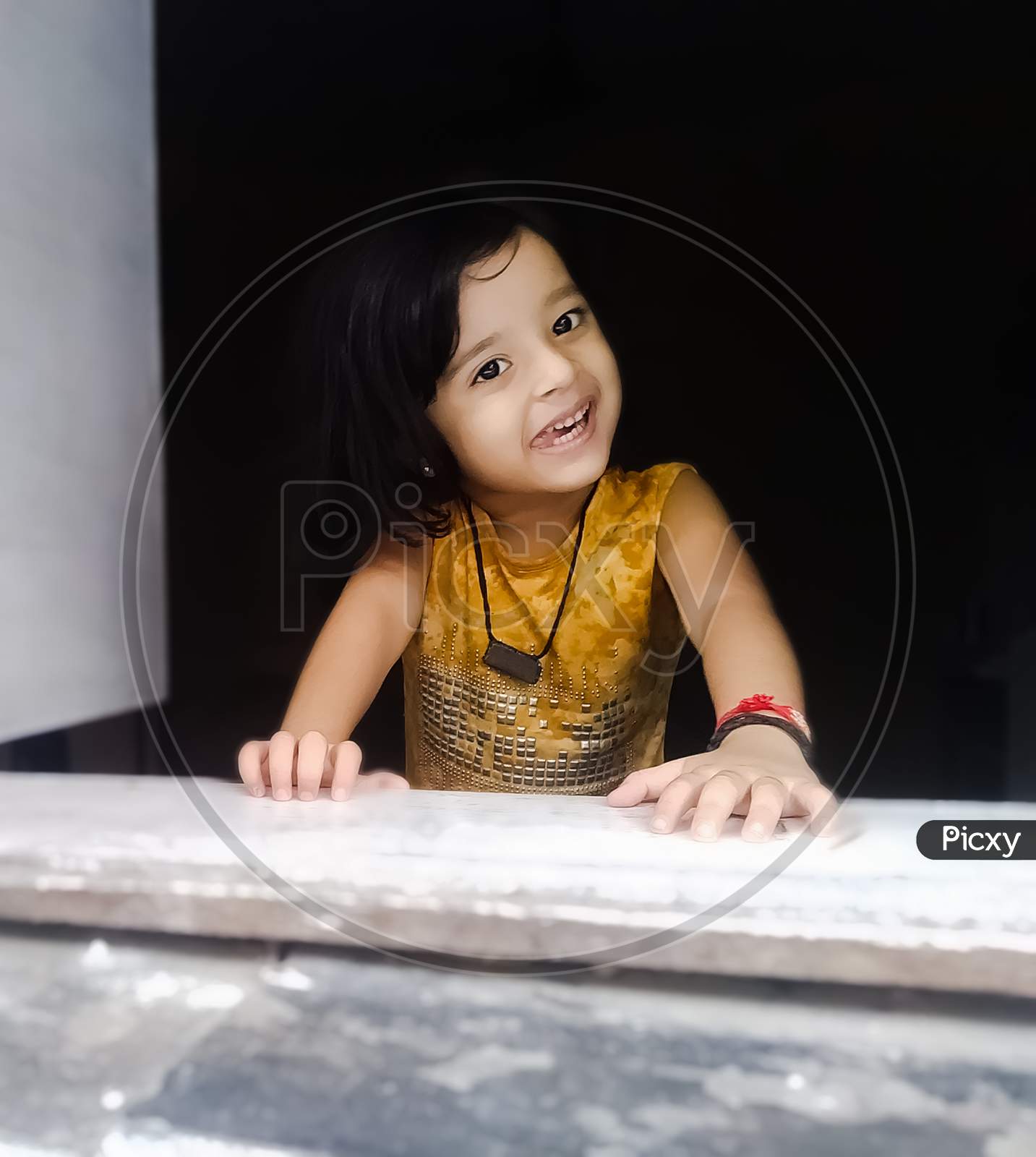 Image of Cute Indian girl looking through window at home-LS752763-Picxy