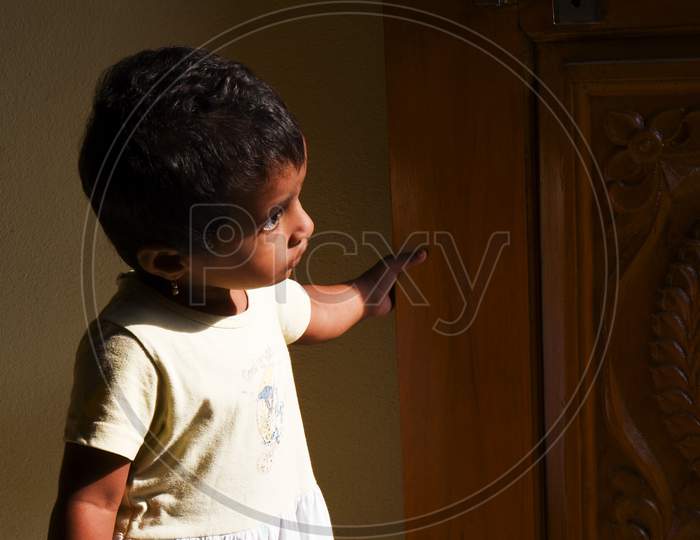 Kalabucloseup Shot Of Indian Girl Child Looking Outside In The Morning Sunlight