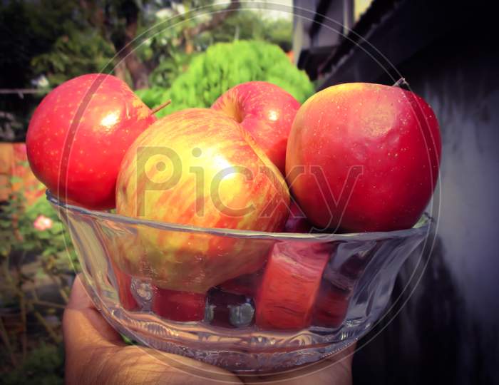 A Jar full of fresh Apple in hand