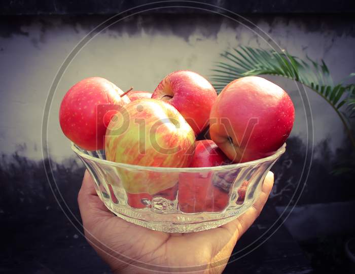 A Jar full of fresh Apple in hand