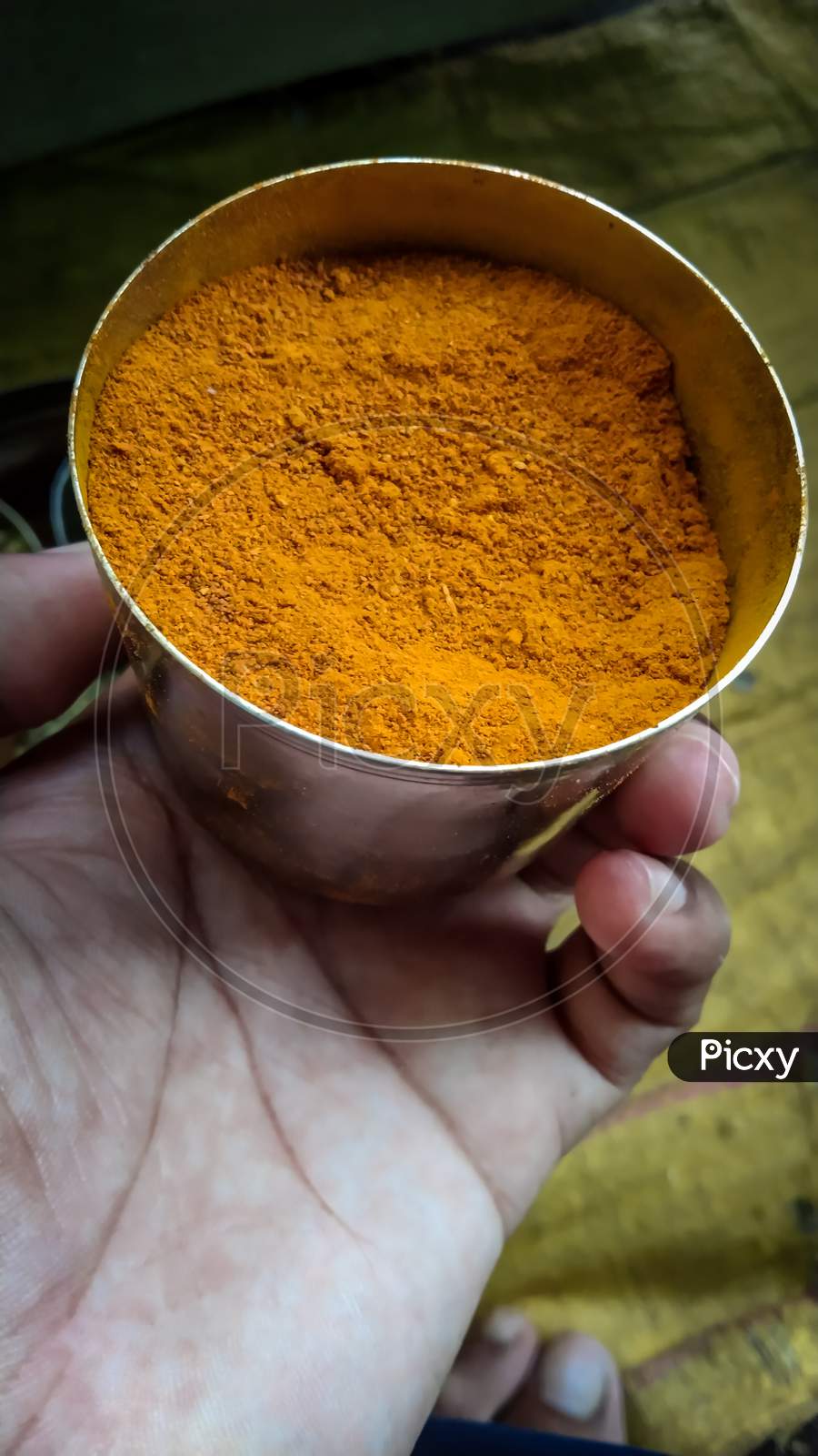 Turmeric powder spice in hand, haldi powder