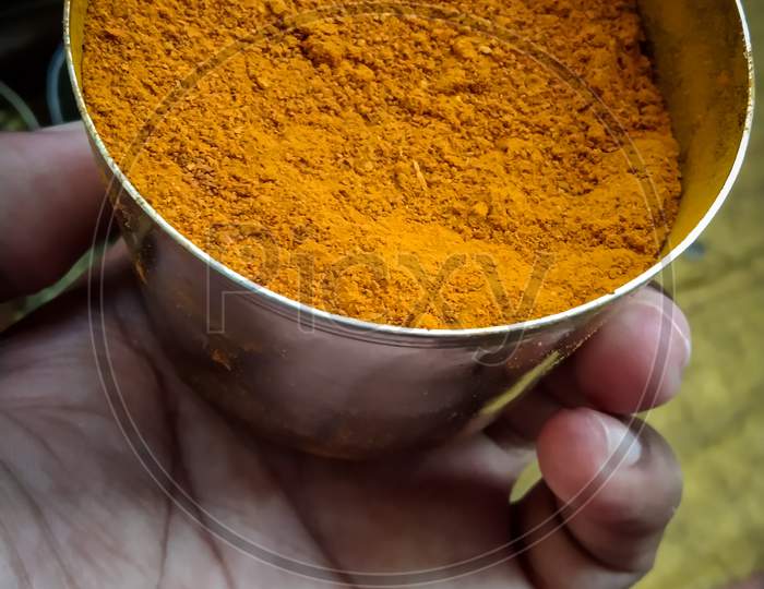 Turmeric powder spice in hand, haldi powder