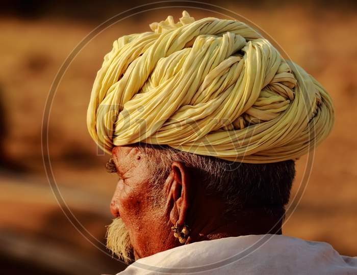 An Abstract side portrait of a Rajasthani man wearing a yellow turban