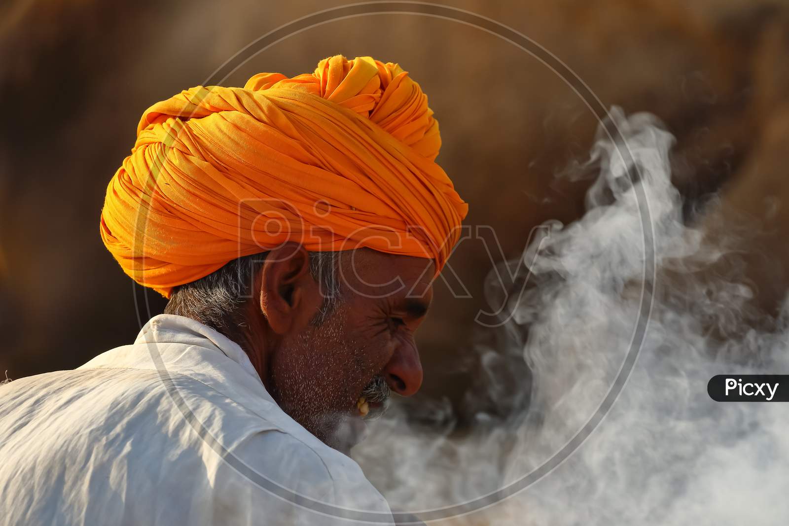 An Abstract side portrait of a Rajasthani man wearing an orange turban with smoke around him