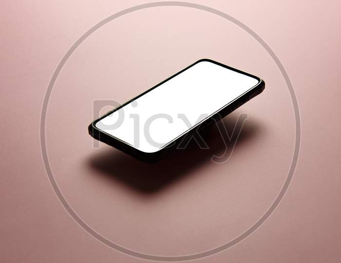 Minimalistic Mock Up Flat Image Design Of A Mobile Phone With Copy Space And White Scree To Write Over It Over A Flat Pastel Pink Background