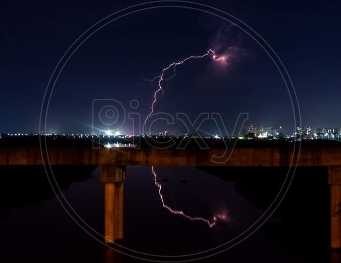 Lightning Storm With Reflection Of Lightning Over The City Bride. Lightning Bolt Strike During A Thunderstorm On Metropolitan City. Dark Sky With Bright Electrical Flash, Thunder And Thunderbolt.