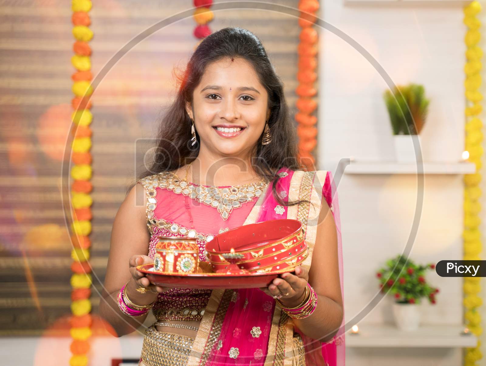 Portrit Shot Of Indian Married Woman In Traditional Dress Holding Karva Chauth Thali Or Plate During Hindu Indian Religious Karwa Chauth Festival.