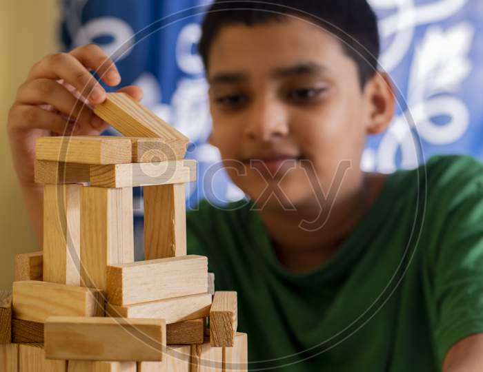 Boy Enjoying Building Castle From Wooden Blocks