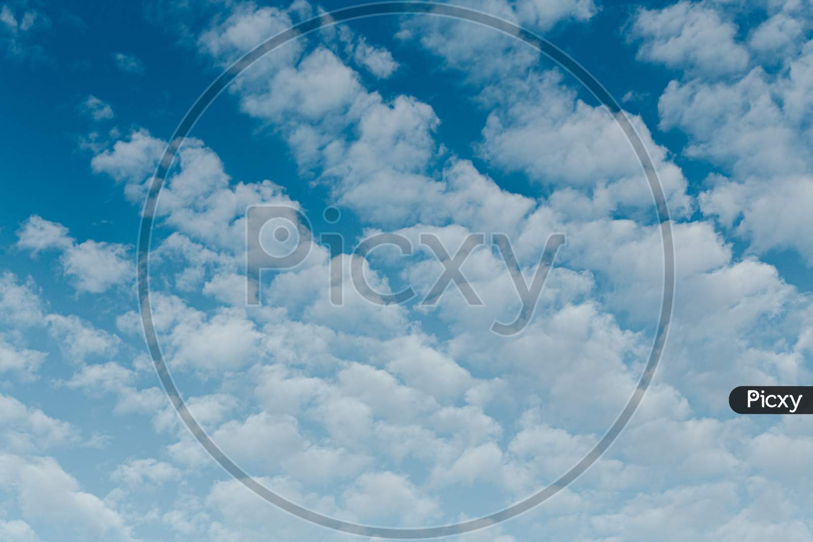 Blue Sky Background Filled With White Big Clouds With Copy Space